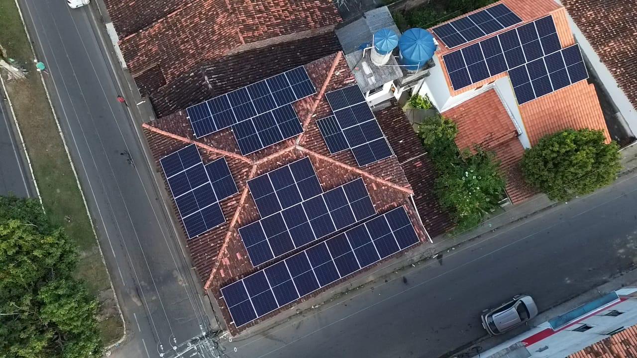 Vista aérea de painéis solares sobre telhados de telhas cerâmicas.